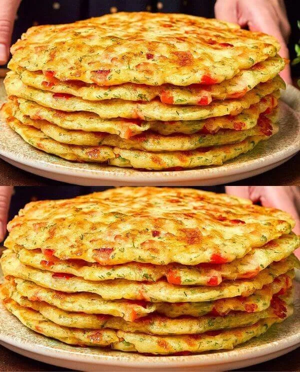 Palacinky z kapusty, cukety a zemiakov na tanieri s čerstvou zeleninou.